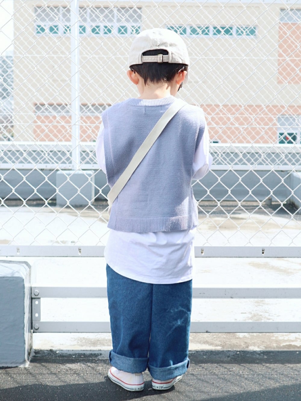 ホワイト系のTシャツ/カットソー、ブルー系のベスト、ホワイト系のショルダーバッグを着用したキッズの春コーディネートの3枚目の写真