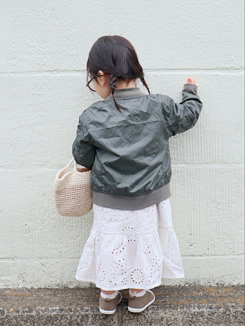 グリーン系のMA-1、ピンク系のTシャツ/カットソー、ベージュ系のかごバッグを着用したキッズの春コーディネートの3枚目の写真