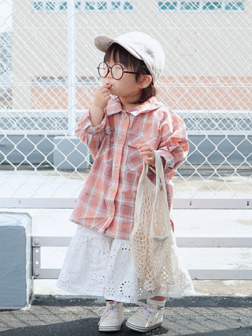 ピンク系のシャツ/ブラウス、ホワイト系のスカート、ホワイト系のスニーカーを着用したキッズの春コーディネートの2枚目の写真