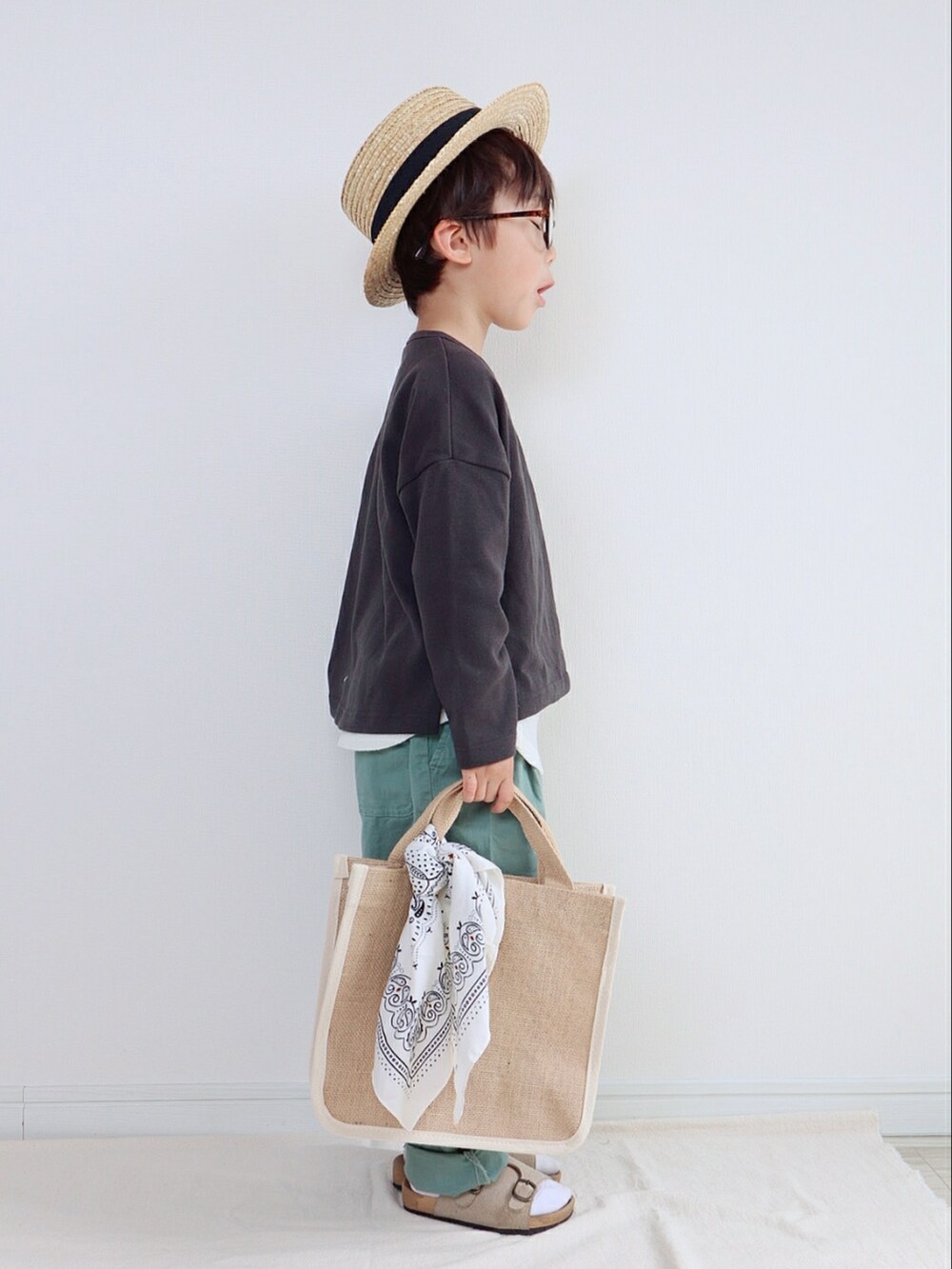 ブラック系のTシャツ/カットソー、グリーン系のその他パンツ、ベージュ系のトートバッグを着用したキッズの春コーディネートの2枚目の写真