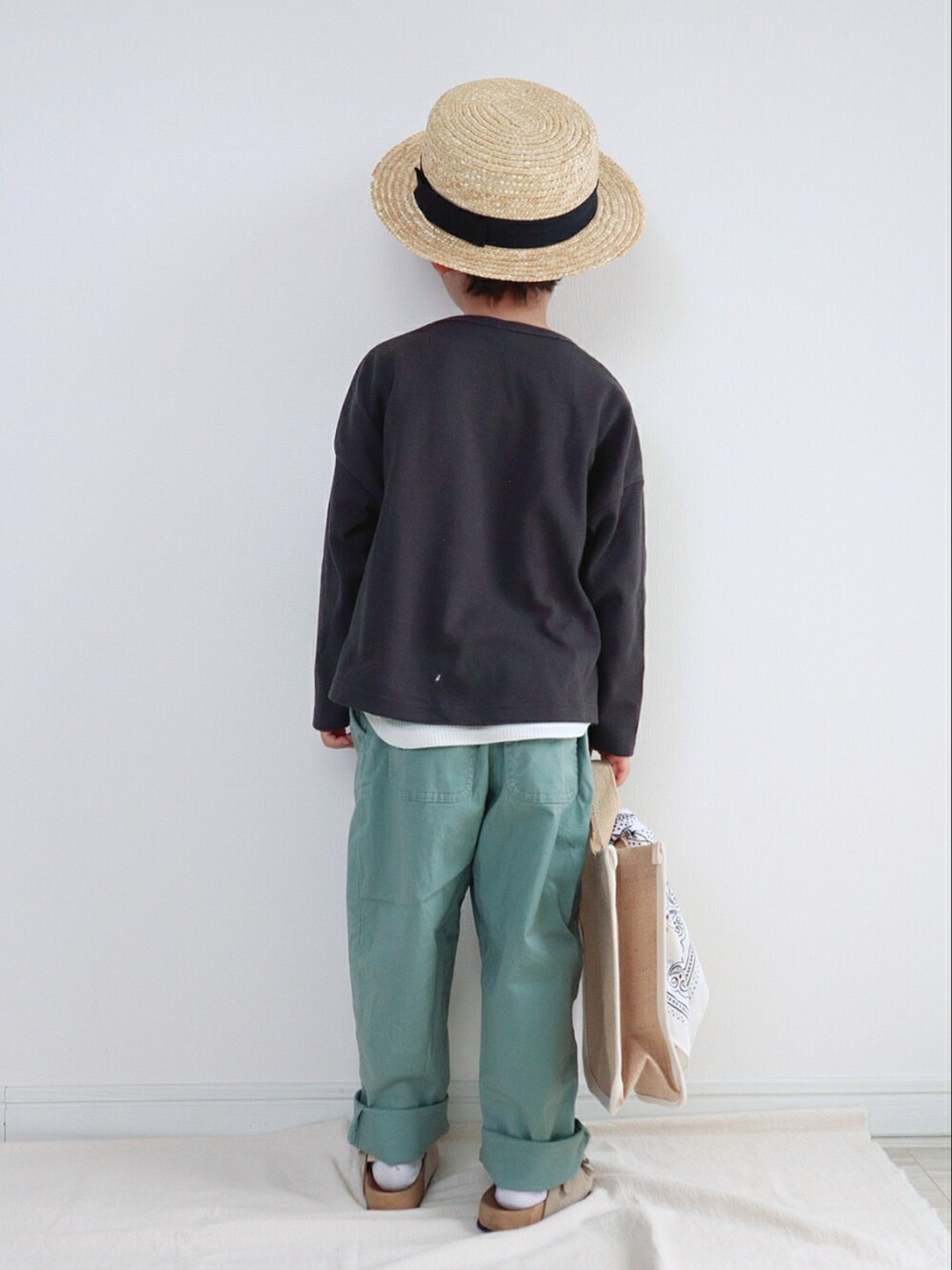 ブラック系のTシャツ/カットソー、グリーン系のその他パンツ、ベージュ系のトートバッグを着用したキッズの春コーディネートの3枚目の写真