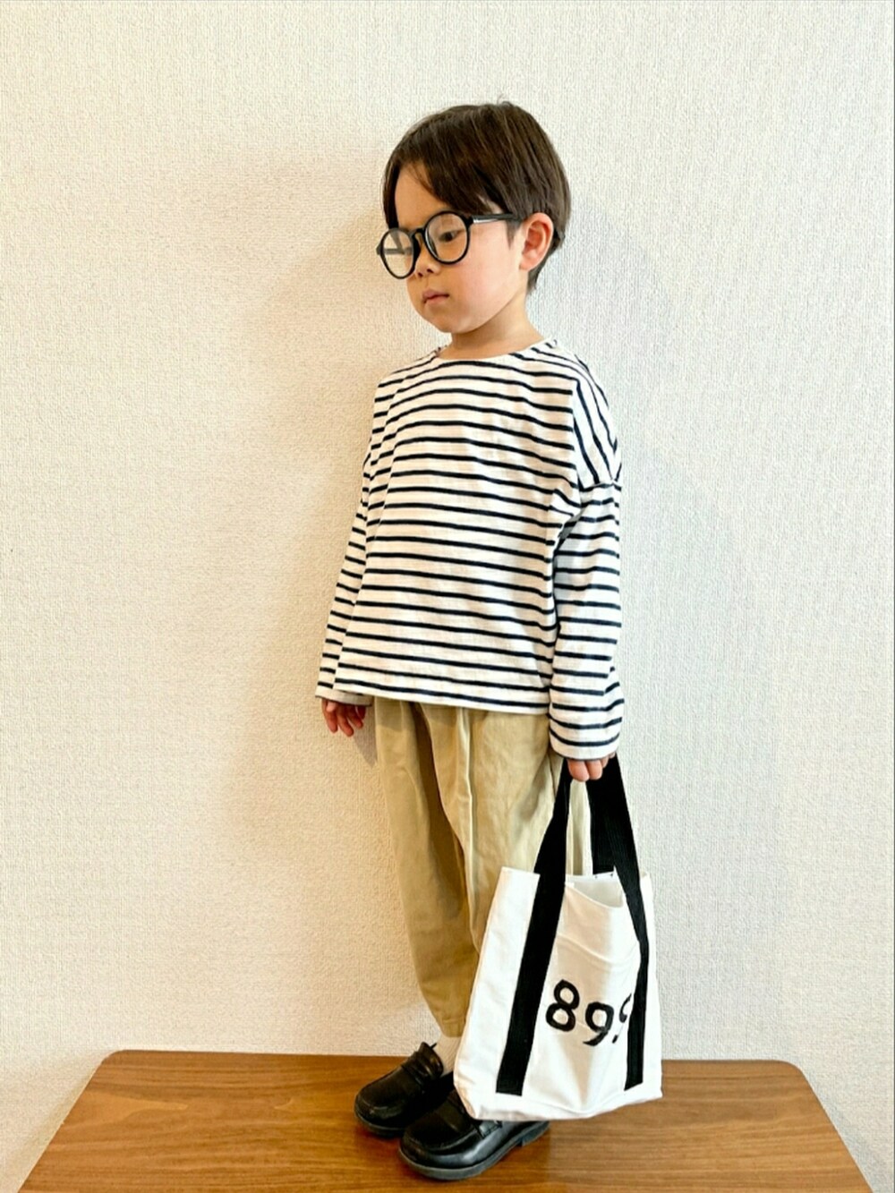 グリーン系のTシャツ/カットソー、ベージュ系のその他パンツ、ベージュ系のトートバッグを着用したキッズの春コーディネートの2枚目の写真