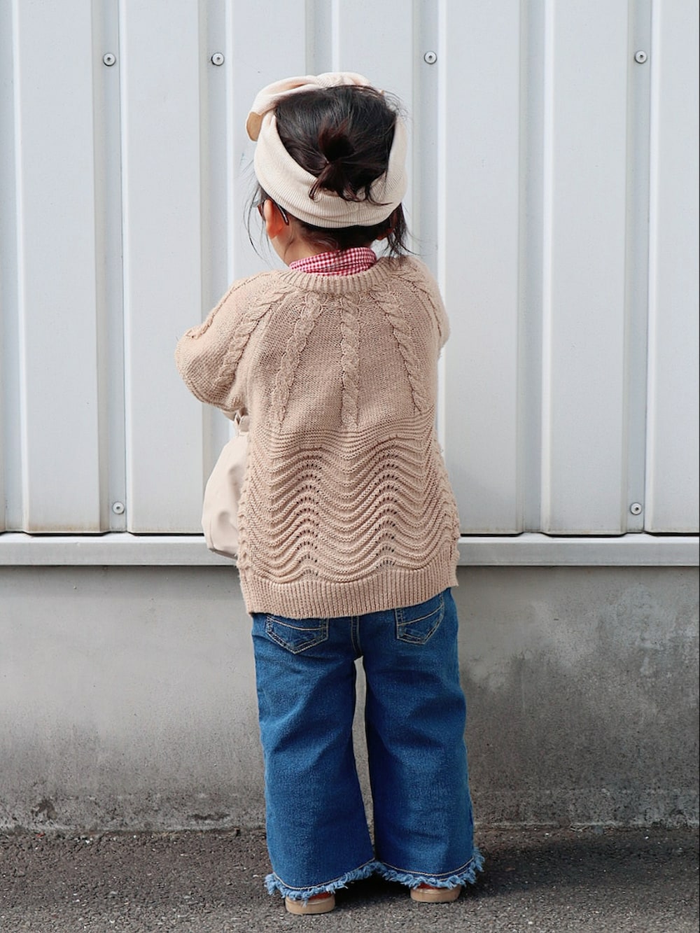 レッド系のシャツ/ブラウス、ベージュ系のカーディガン/ボレロ、ブルー系のデニムパンツを着用したキッズの春コーディネートの2枚目の写真