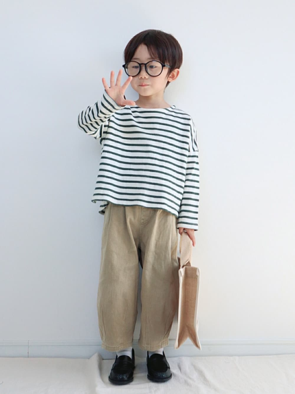 グリーン系のTシャツ/カットソー、ベージュ系のその他パンツ、ベージュ系のトートバッグを着用したキッズの春コーディネートの4枚目の写真