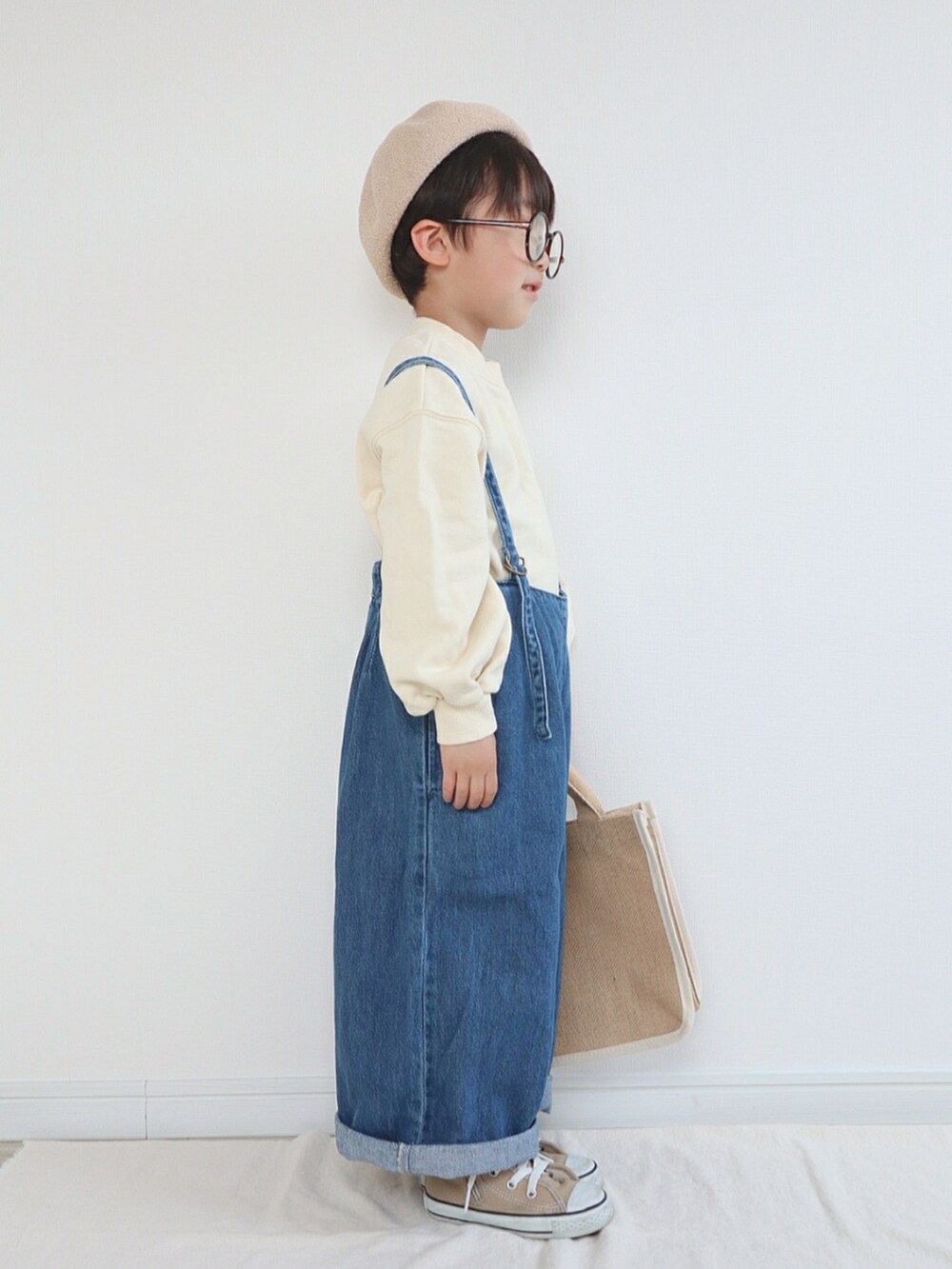 ホワイト系のスウェット、ブルー系のサロペット/オーバーオール、ベージュ系のトートバッグを着用したキッズの春コーディネートの2枚目の写真