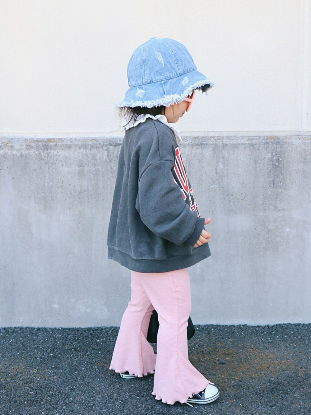 グレー系のスウェット、ブラック系のトートバッグ、ピンク系のパンツを着用したキッズの春コーディネートの2枚目の写真