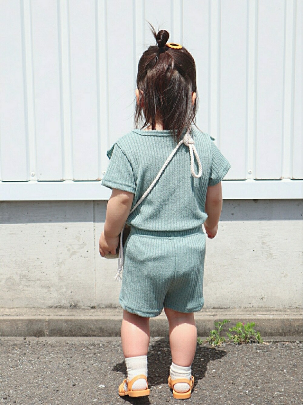 グリーン系のTシャツ/カットソー、グリーン系のパンツ、ベージュ系のショルダーバッグを着用したキッズの春コーディネートの2枚目の写真