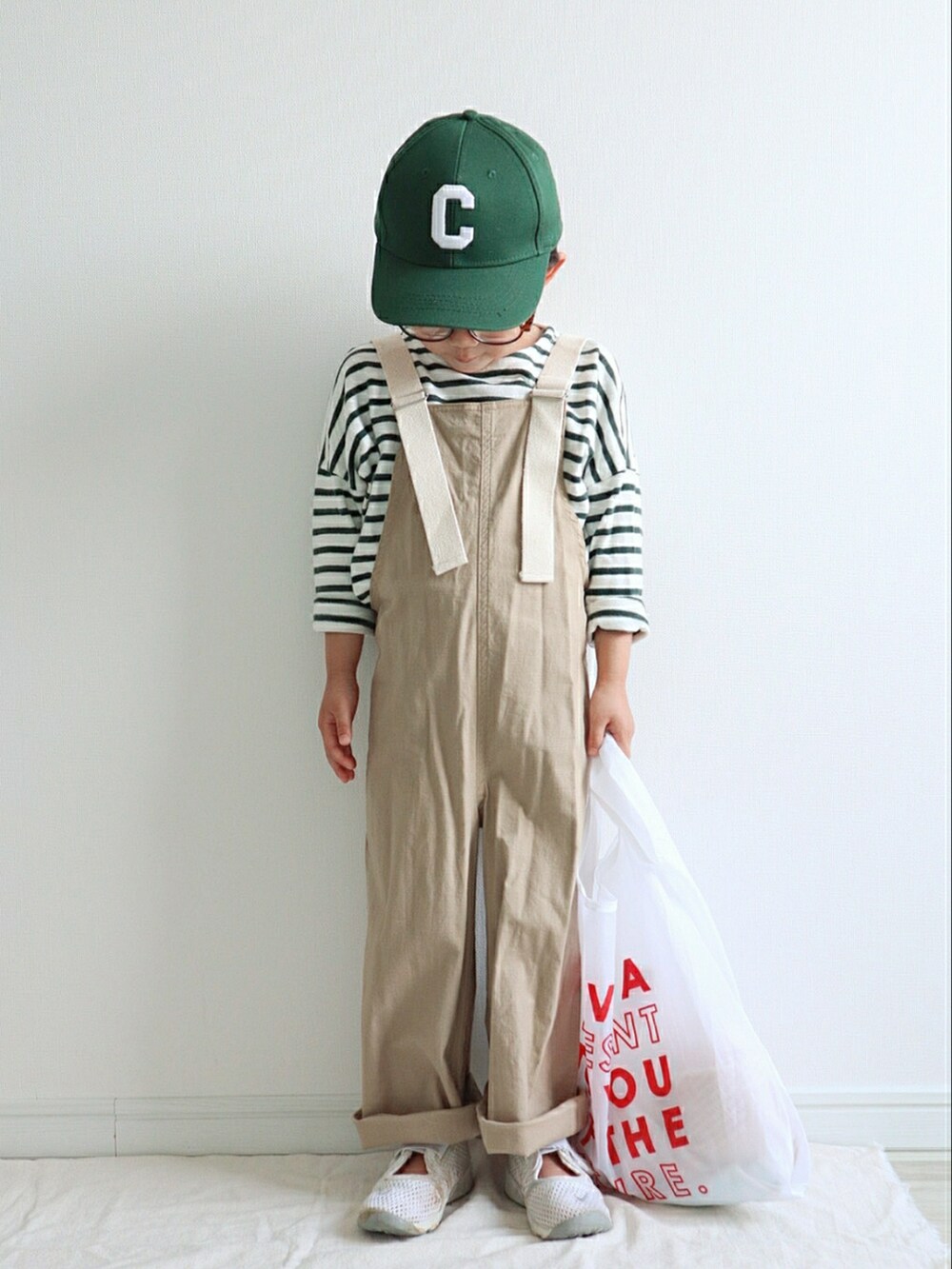 グリーン系のTシャツ/カットソー、ベージュ系のサロペット/オーバーオール、ホワイト系のエコバッグ/サブバッグを着用したキッズの春コーディネートの2枚目の写真