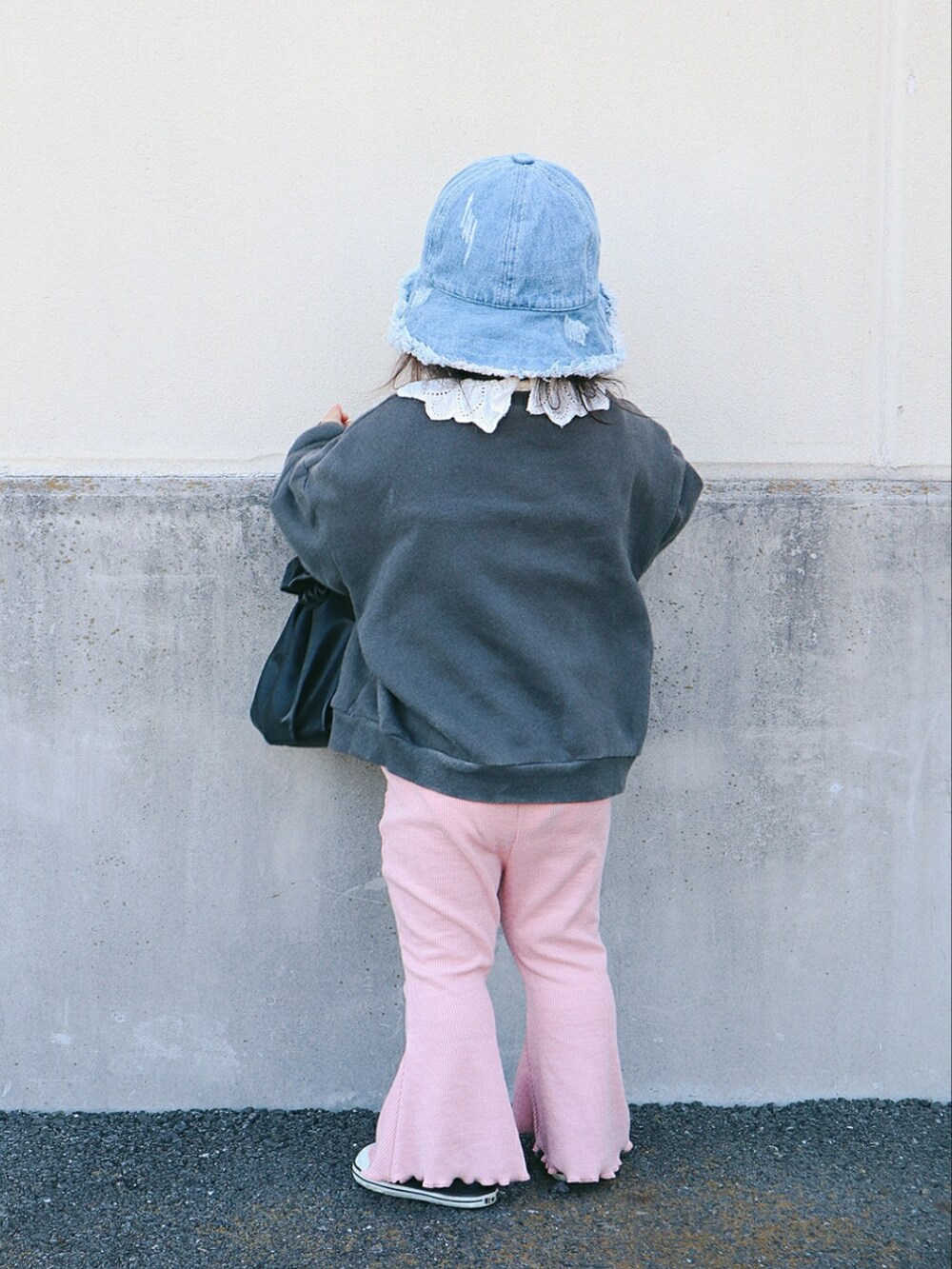 グレー系のスウェット、ブラック系のトートバッグ、ピンク系のパンツを着用したキッズの春コーディネートの3枚目の写真