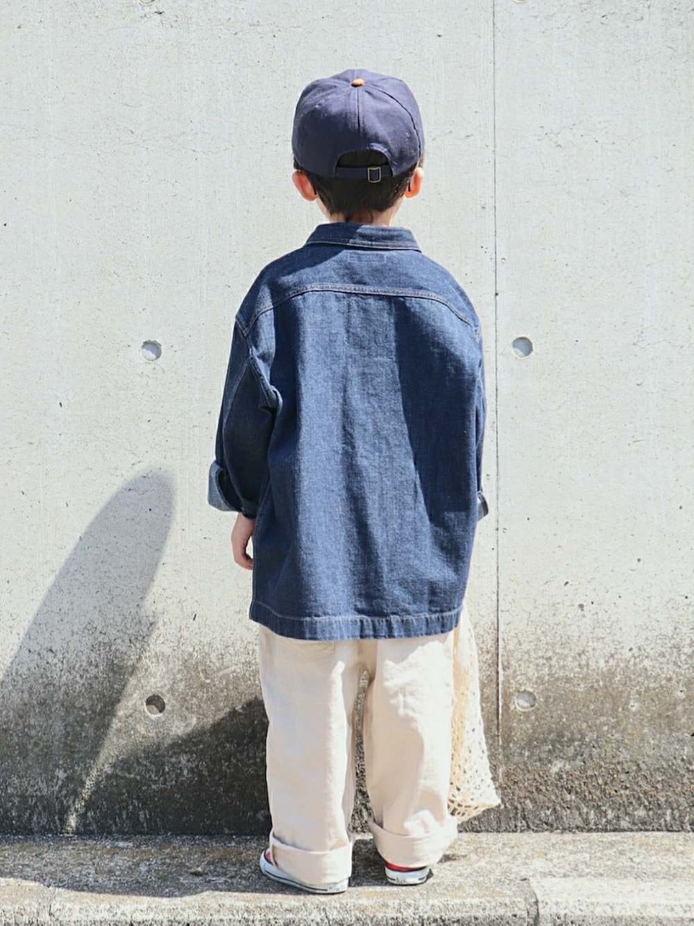 ブルー系のデニムジャケット、グレー系のTシャツ/カットソー、ベージュ系のパンツを着用したキッズの春コーディネートの3枚目の写真