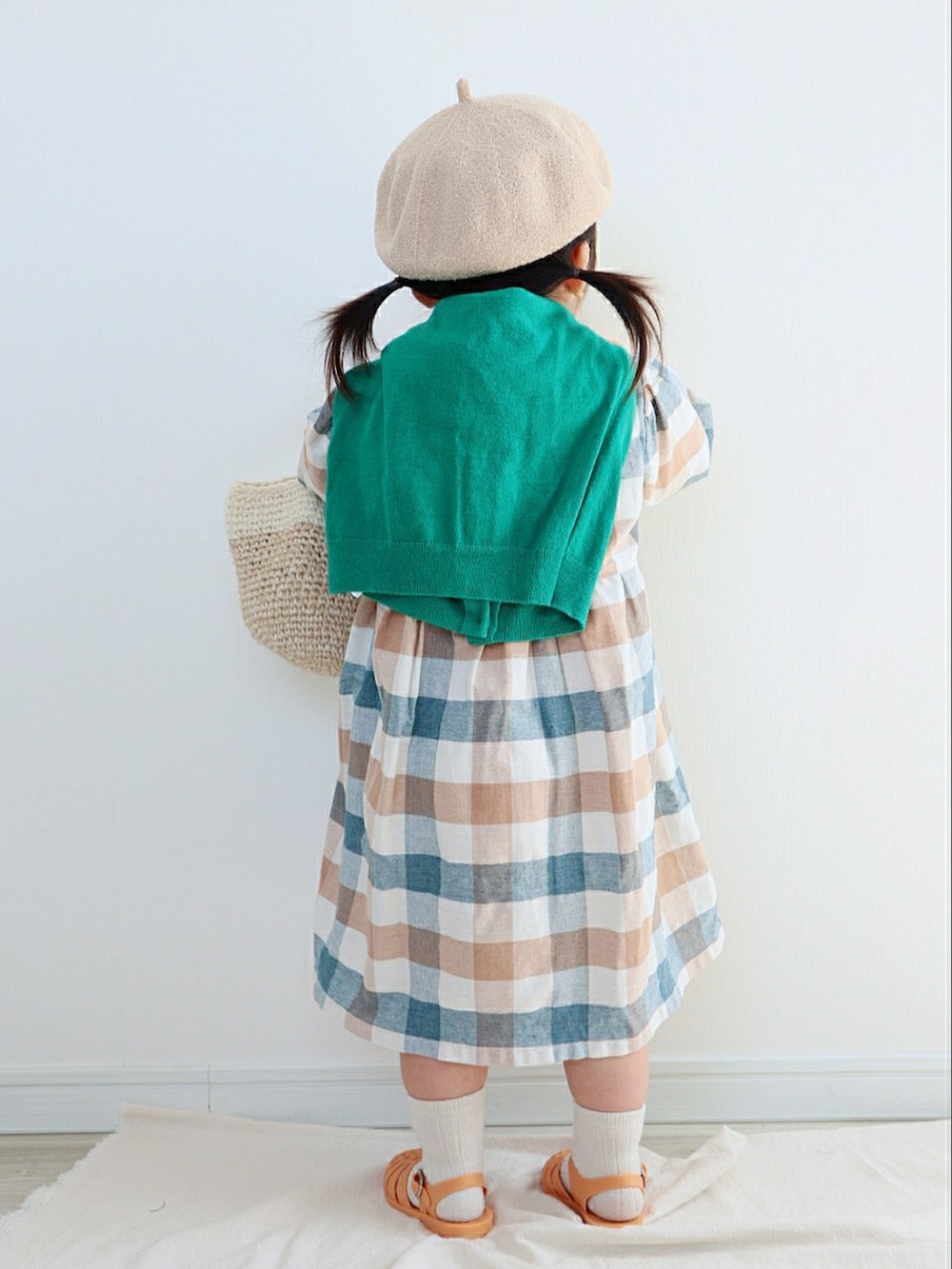 その他のワンピース、ベージュ系のかごバッグ、オレンジ系のサンダルを着用したキッズの春コーディネートの3枚目の写真