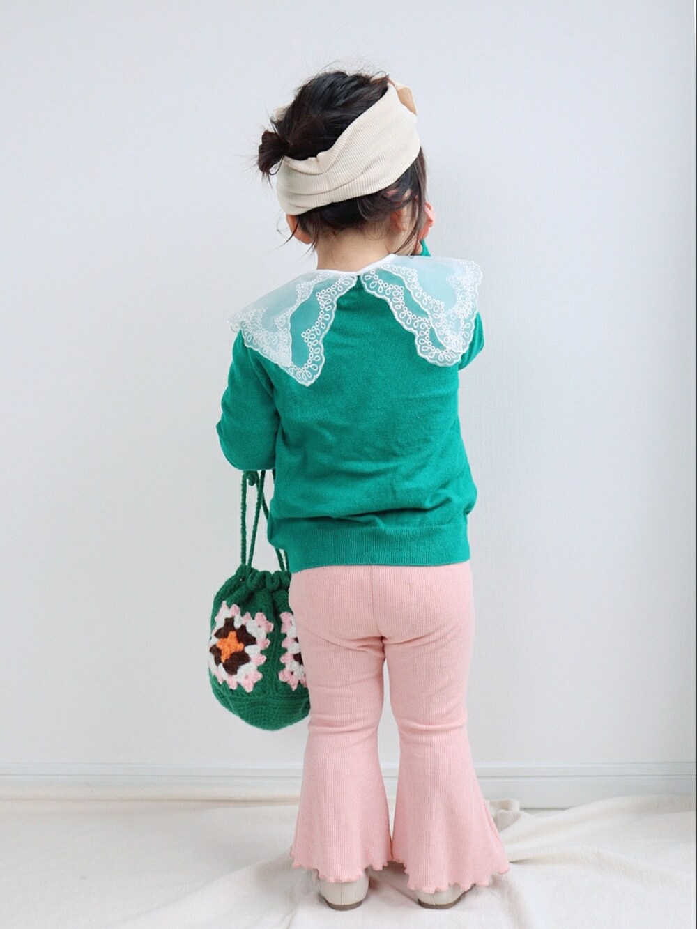 グリーン系のカーディガン/ボレロ、グリーン系のバッグ、ピンク系のパンツを着用したキッズの春コーディネートの3枚目の写真