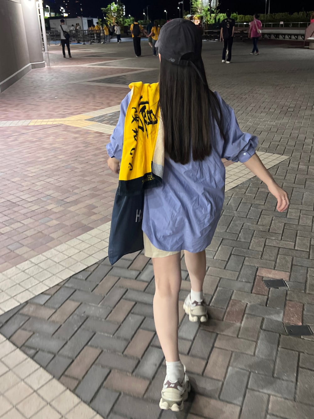 ブルー系のトートバッグ、ブルー系のシャツ/ブラウス、グレー系のスニーカーを着用したレディースの秋コーディネートの2枚目の写真