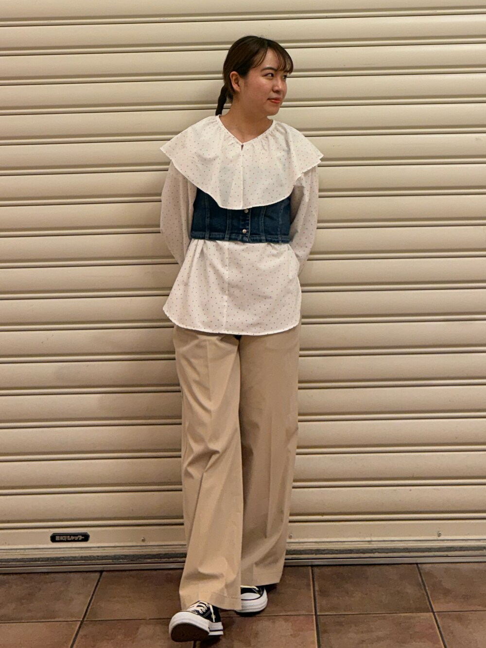 ブラック系のスニーカー、ベージュ系のチノパンツ、ベージュ系のショルダーバッグを着用したレディースの春コーディネートの2枚目の写真