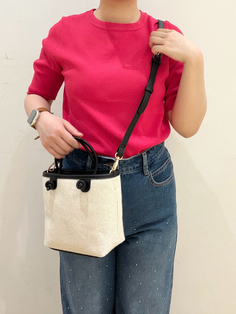 ブラック系のドレスシューズ、ブルー系のデニムパンツ、ピンク系のニット/セーターを着用したレディースの春コーディネートの3枚目の写真