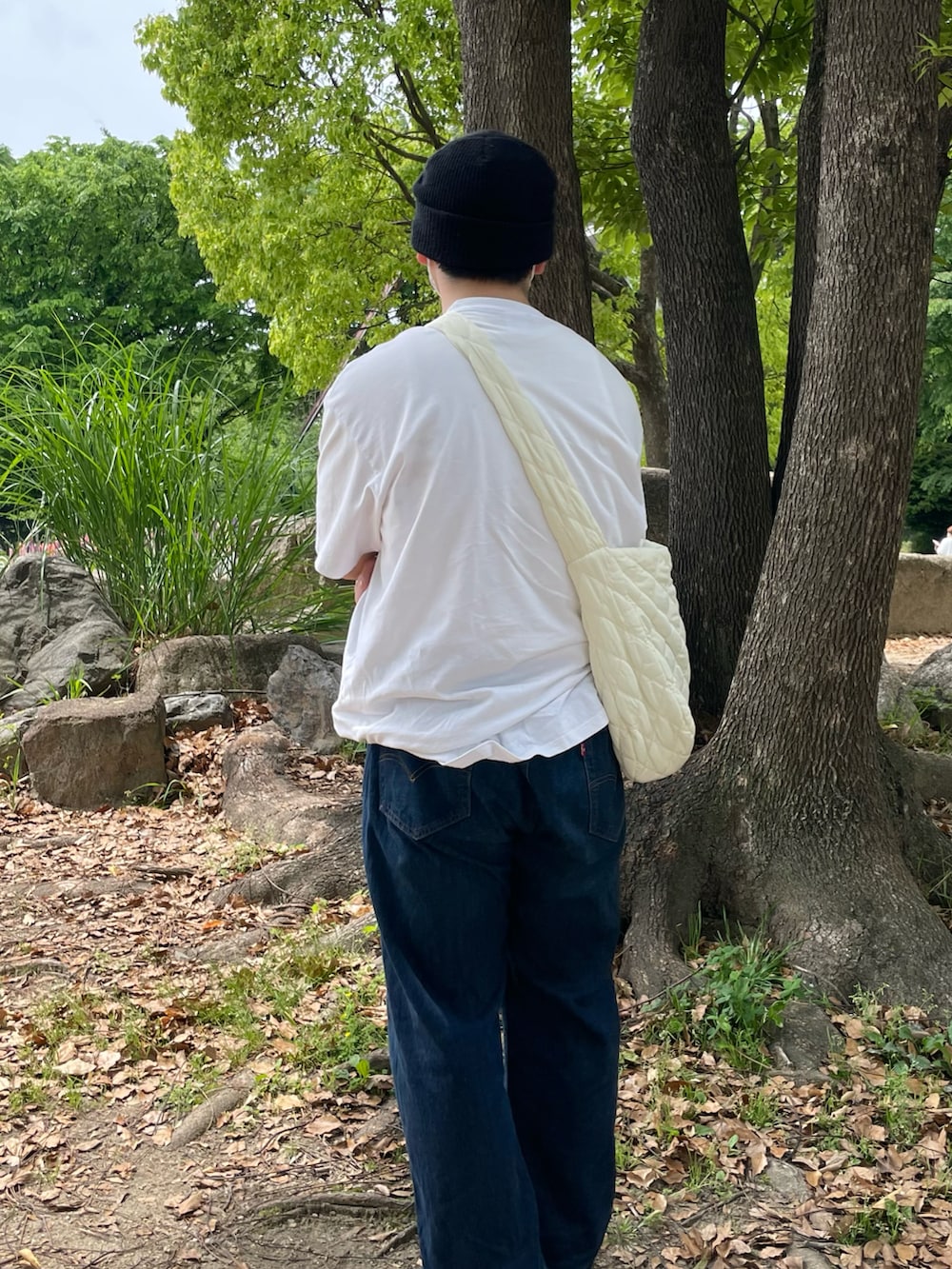 ブラック系のスニーカー、ホワイト系のショルダーバッグ、ホワイト系のTシャツ/カットソーを着用したメンズの春コーディネートの3枚目の写真