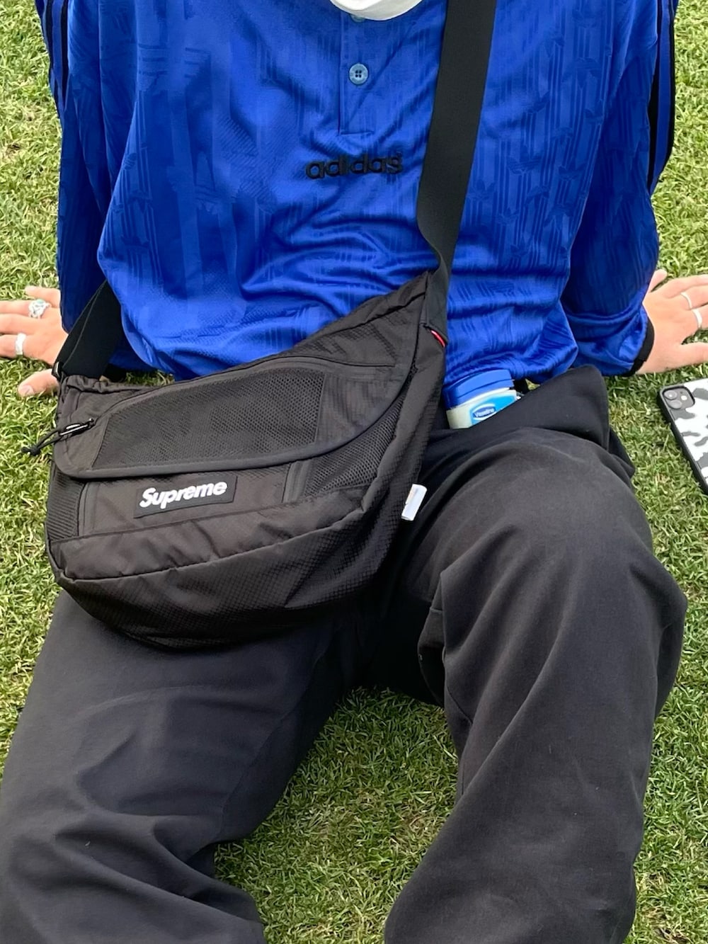 ブラック系のカーゴパンツ、ブラック系のメッセンジャーバッグ、ブラック系のスニーカーを着用したメンズの春コーディネートの2枚目の写真