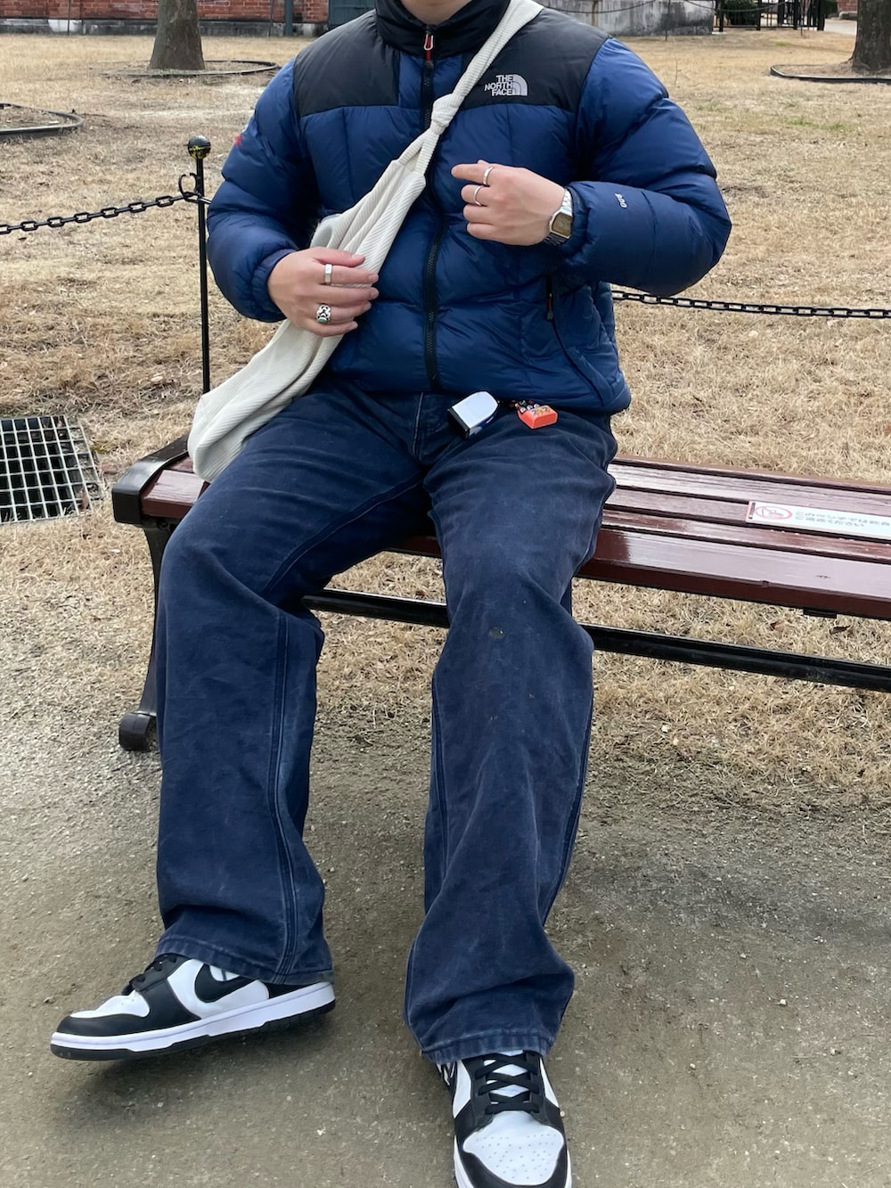 ブルー系のダウンジャケット/コート、ブルー系のデニムパンツ、ブラック系のスニーカーを着用したメンズの春コーディネートの2枚目の写真