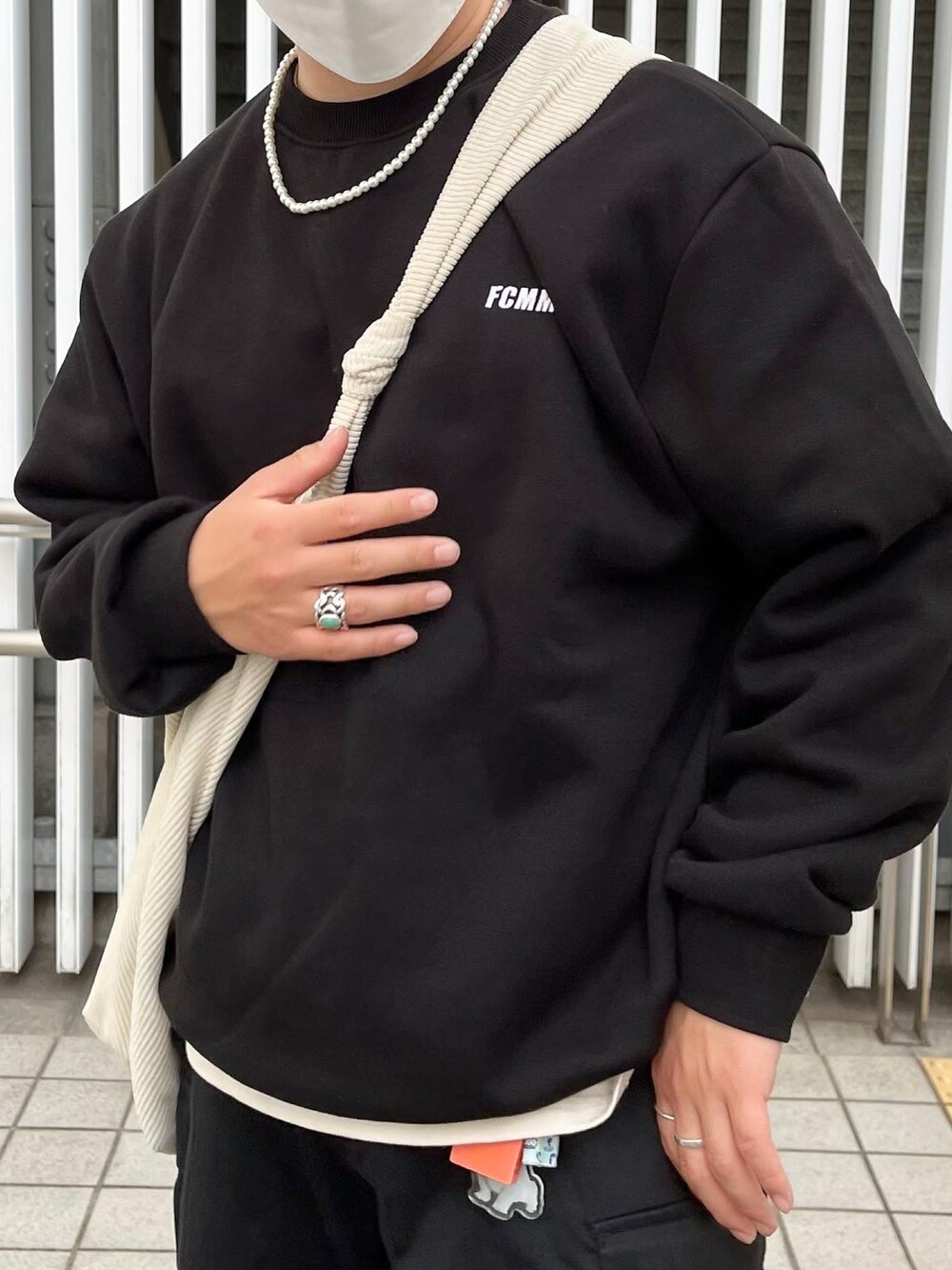 ブラック系のスウェット、ブラック系のスニーカー、ホワイト系のショルダーバッグを着用したメンズの春コーディネートの3枚目の写真