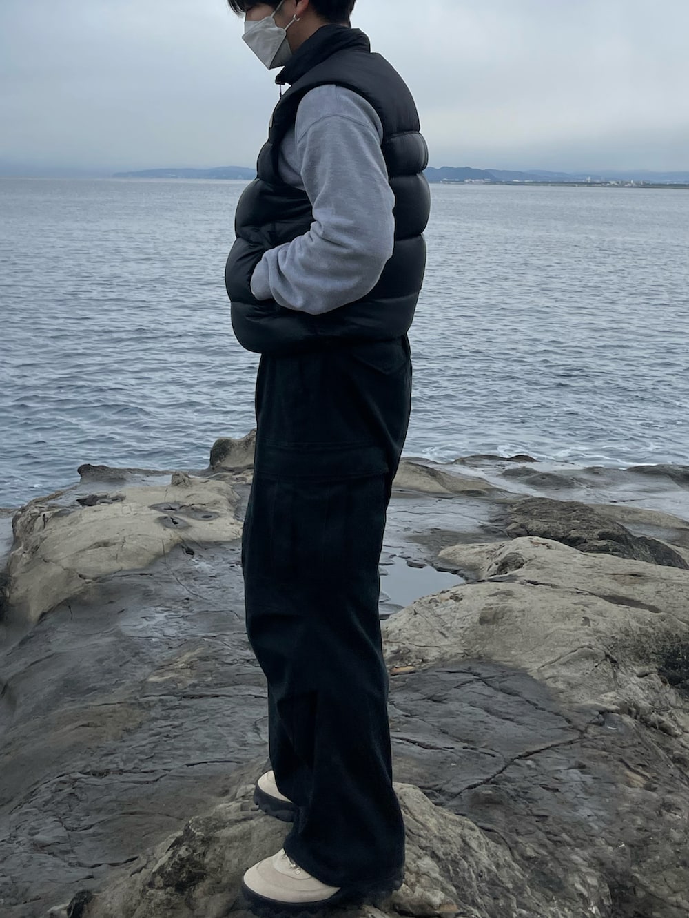 ブラック系のカーゴパンツ、ブラック系のダウンベスト、グレー系のスウェットを着用したメンズの冬コーディネートの2枚目の写真