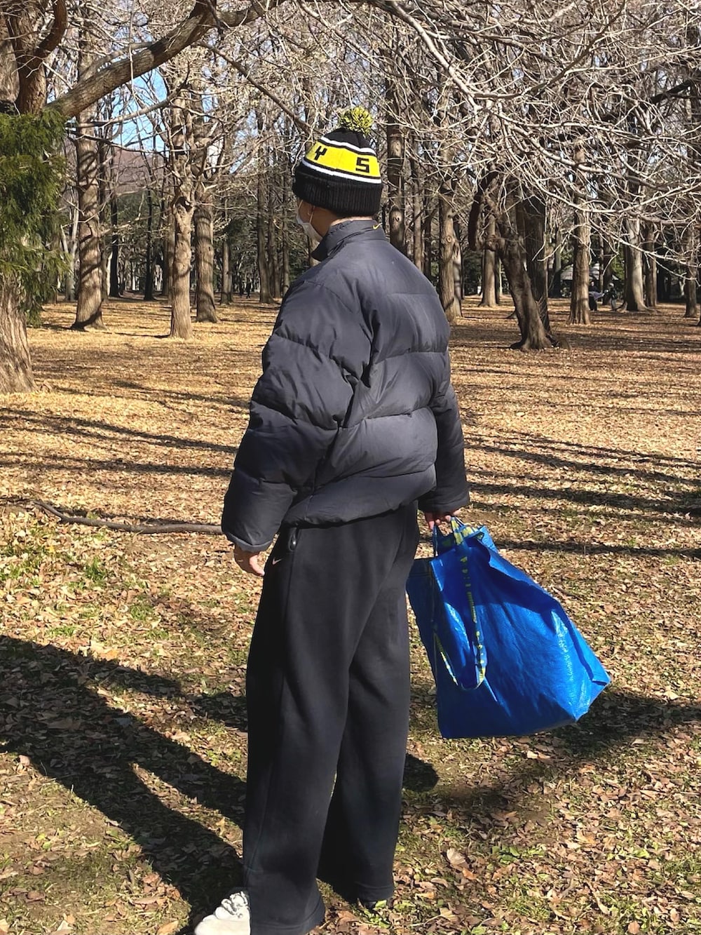 ブラック系のダウンジャケット/コート、ブラック系のスウェットパンツ、ブルー系のバッグを着用したメンズの冬コーディネートの3枚目の写真