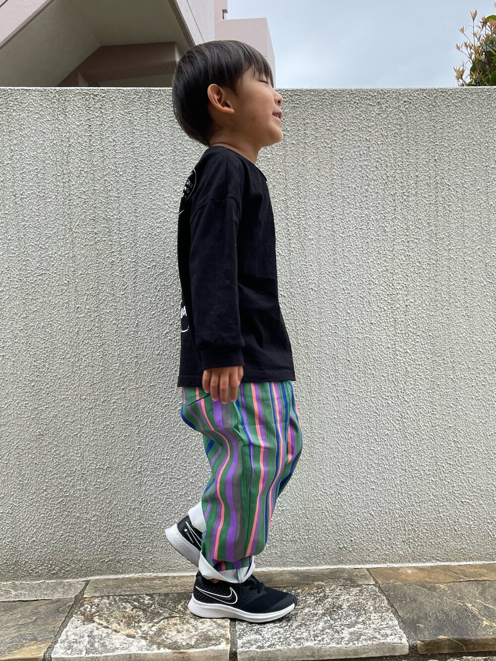 グリーン系のその他パンツ、ブラック系のTシャツ/カットソー、ブラック系のスニーカーを着用したキッズの春コーディネートの2枚目の写真