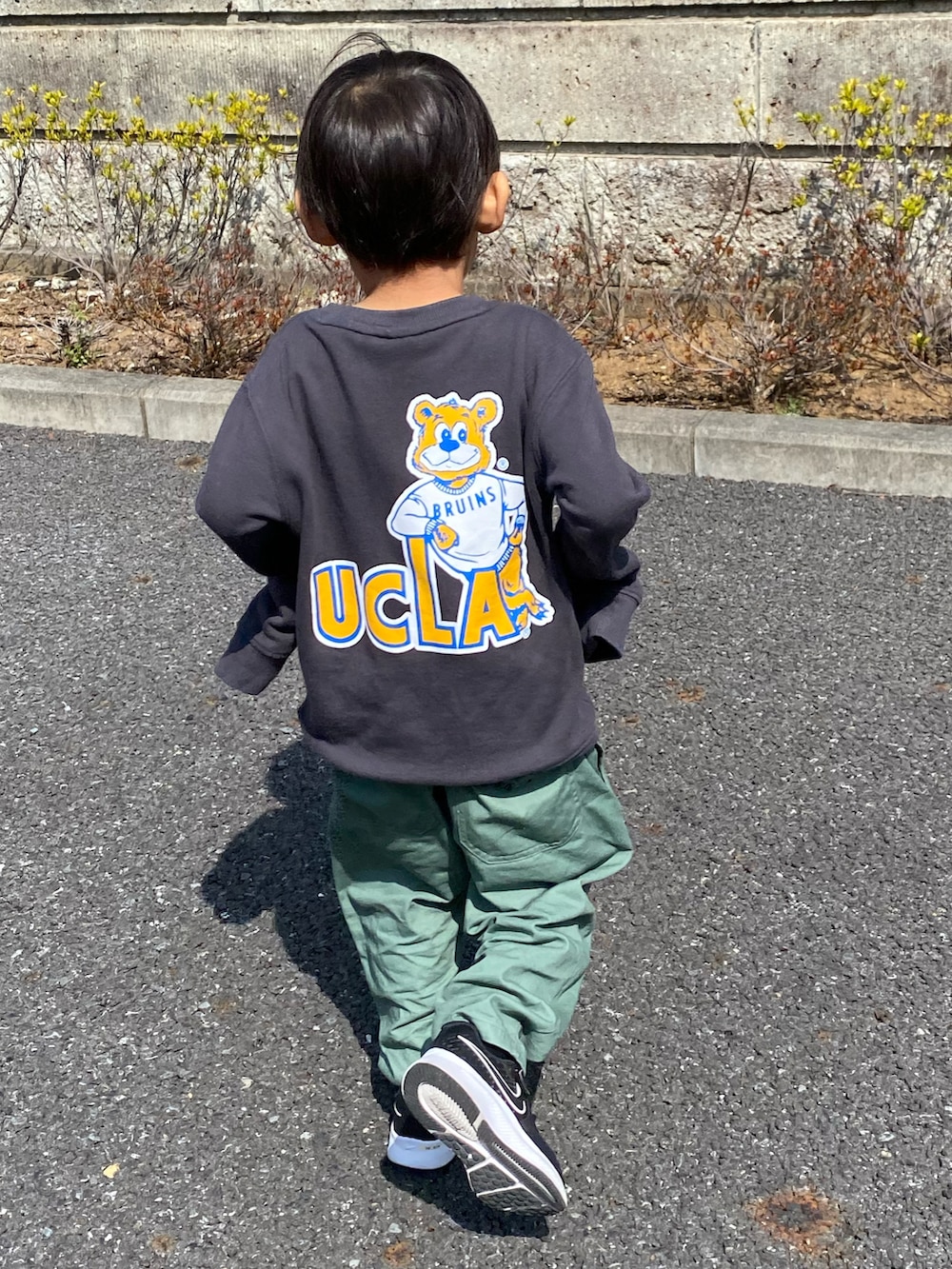 グリーン系のチノパンツ、グレー系のスウェット、ブラック系のスニーカーを着用したキッズの春コーディネートの2枚目の写真