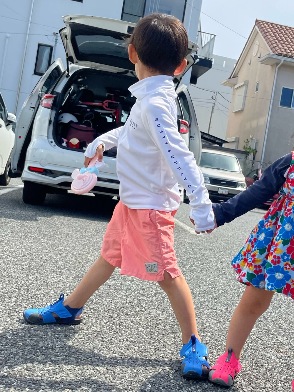 ピンク系のその他パンツ、ブルー系のサンダル、ホワイト系のラッシュガードを着用したキッズの夏コーディネートの2枚目の写真