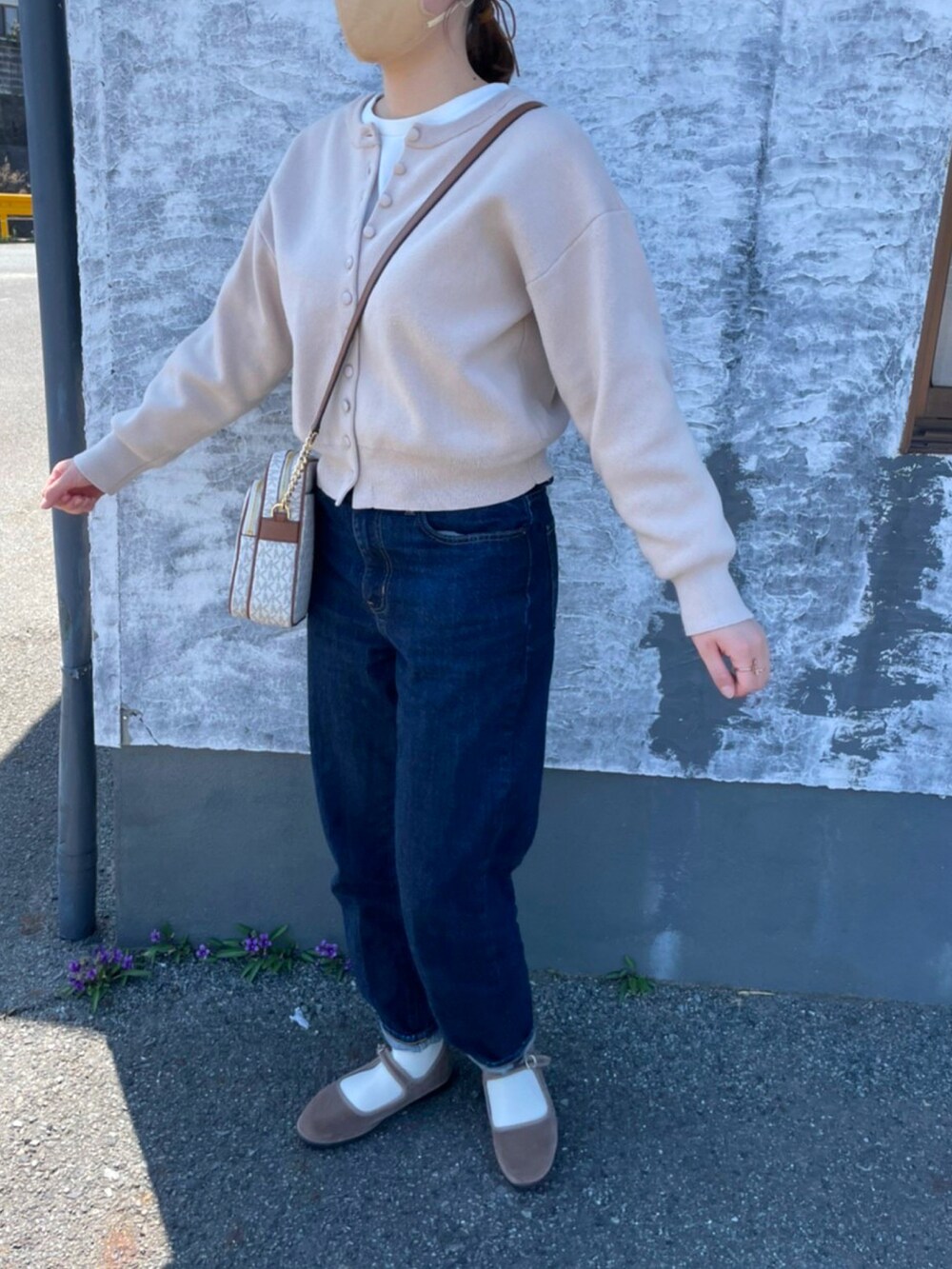 ピンク系のカーディガン/ボレロ、ブルー系のデニムパンツ、ホワイト系のショルダーバッグを着用したレディースの春コーディネートの2枚目の写真