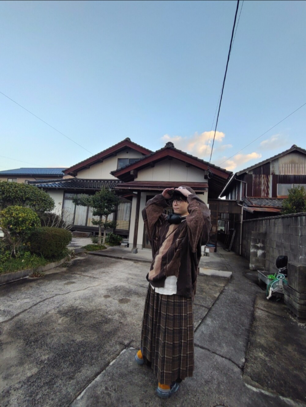 ブラウン系のニット/セーター、ブラウン系のスカート、ブルー系のサンダルを着用したメンズの冬コーディネートの2枚目の写真