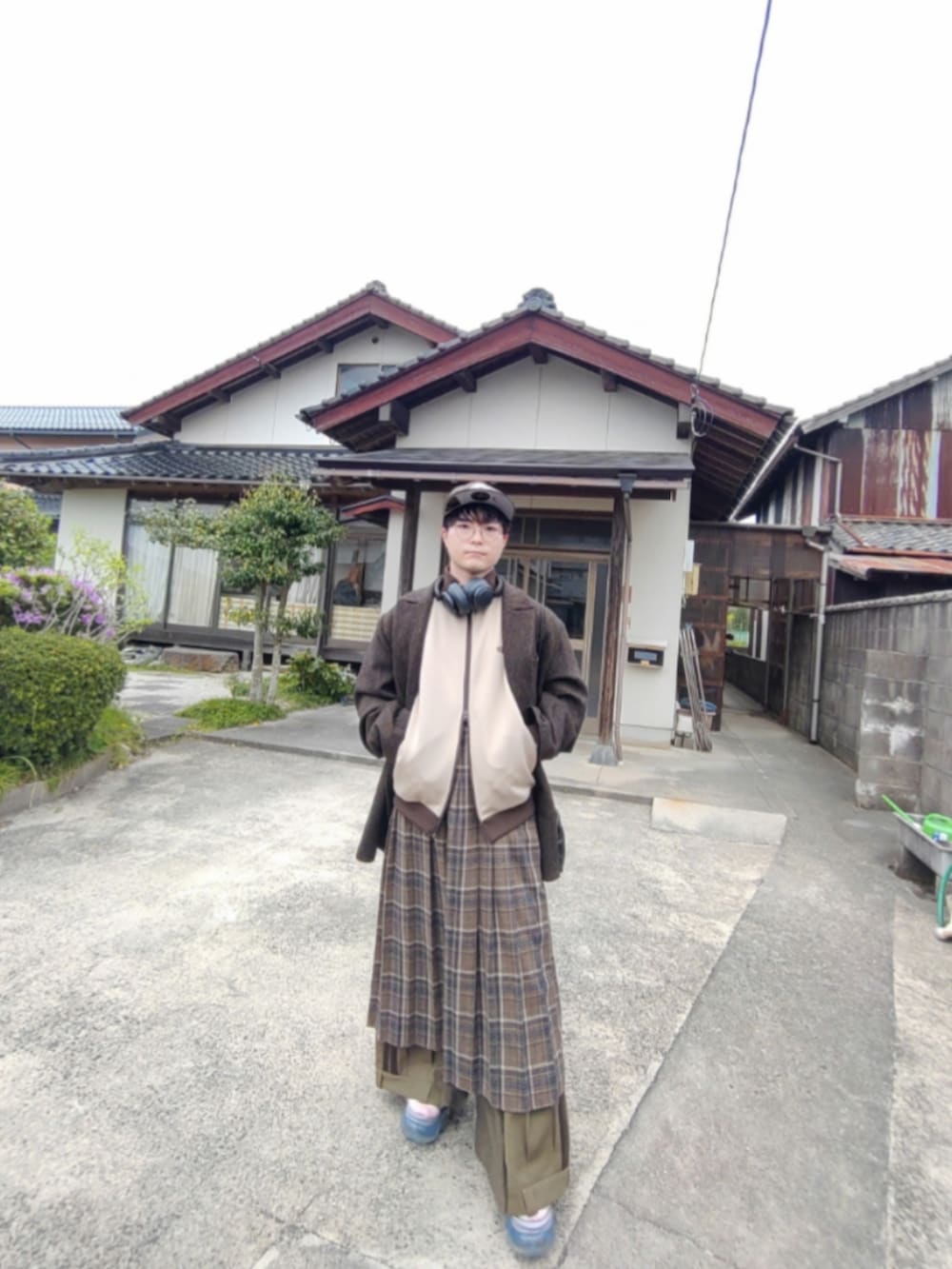 ブラウン系のテーラードジャケット、ブラウン系のスカート、グリーン系のその他パンツを着用したメンズの春コーディネートの2枚目の写真