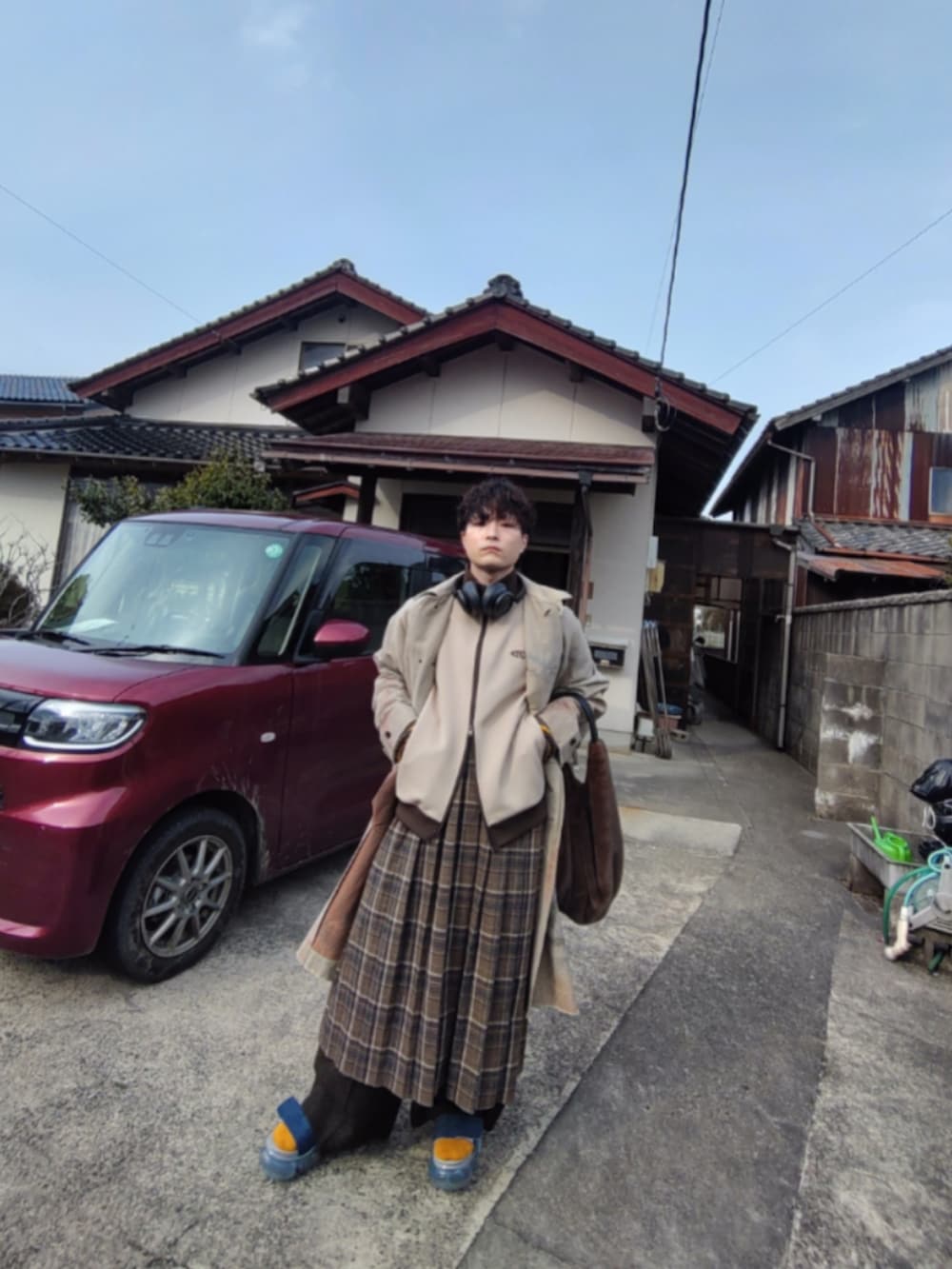 ベージュ系のジャージ、ベージュ系のステンカラーコート、ブラウン系のバッグを着用したメンズの春コーディネートの2枚目の写真