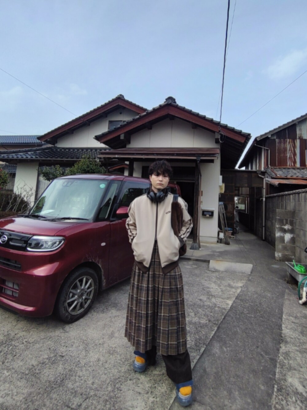ベージュ系のジャージ、ベージュ系のステンカラーコート、ブラウン系のバッグを着用したメンズの春コーディネートの3枚目の写真