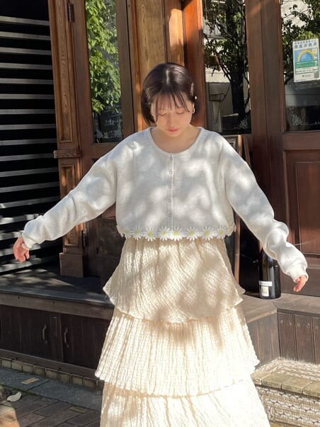 グレー系のカーディガン/ボレロ、ホワイト系のスカート、ホワイト系のローファーを着用したレディースの夏コーディネートの2枚目の写真