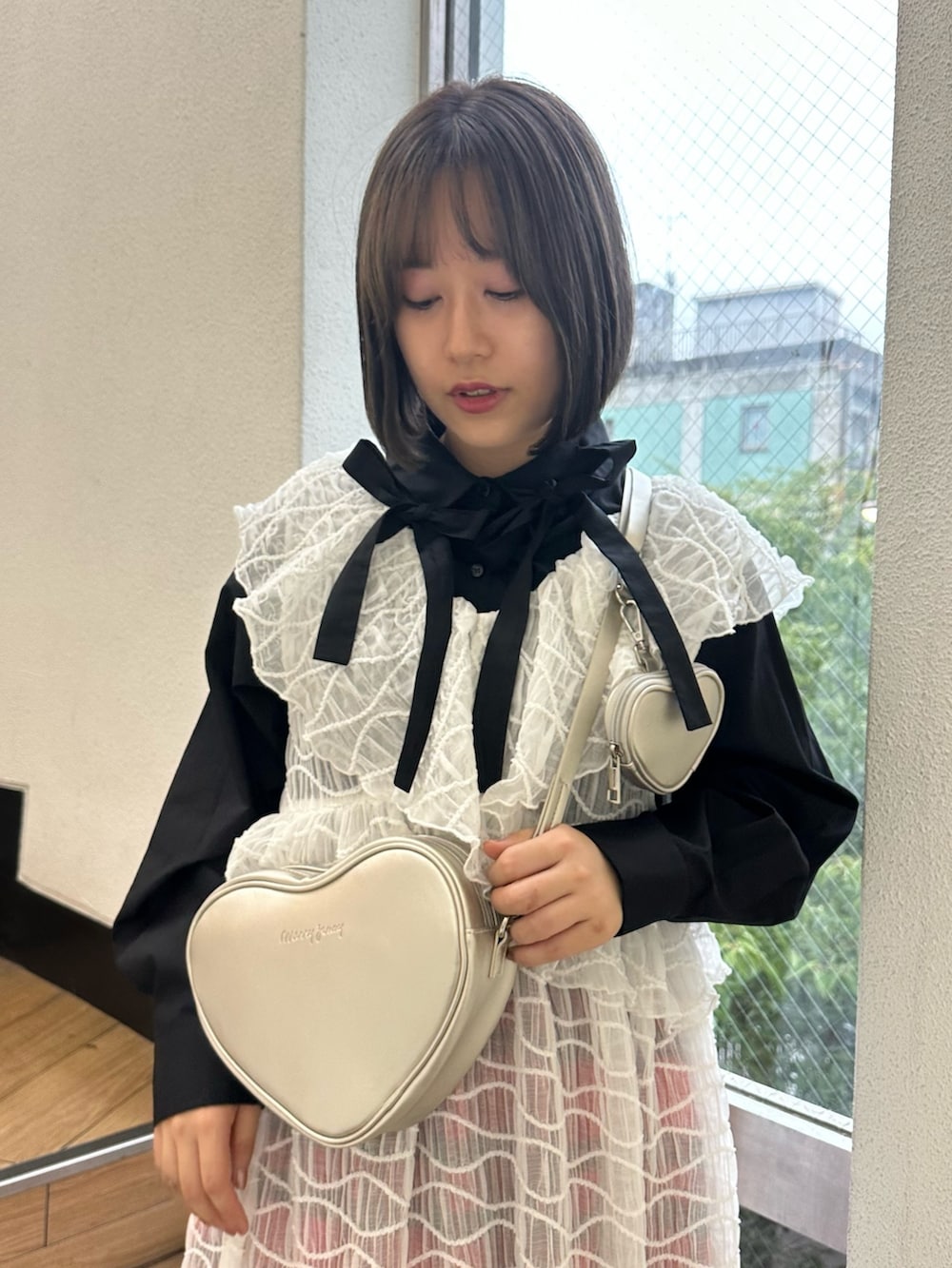 シルバー系のハンドバッグ、レッド系のスカート、ホワイト系のワンピースを着用したレディースの秋コーディネートの3枚目の写真