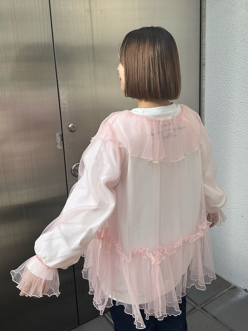 ホワイト系のスニーカー、ブルー系のデニムパンツ、ホワイト系のスウェットを着用したレディースの冬コーディネートの4枚目の写真