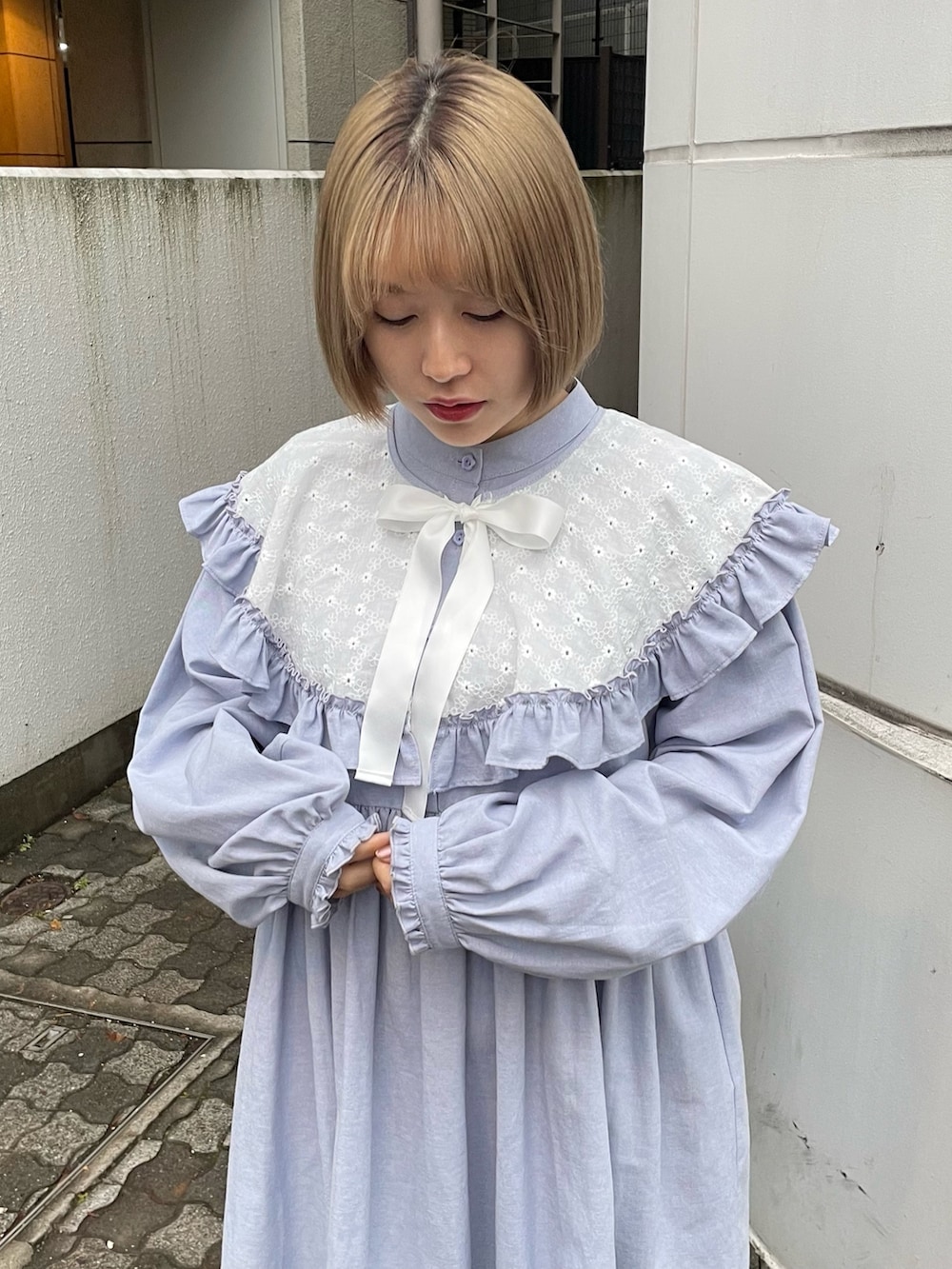 ブルー系のワンピース、ホワイト系のパンプスを着用したレディースの冬コーディネートの4枚目の写真