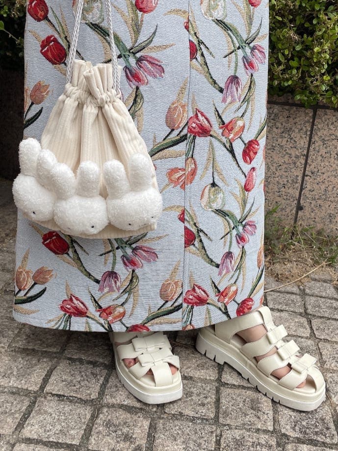 ブルー系のジャンパースカート、ホワイト系のサンダル、ホワイト系のハンドバッグを着用したレディースの春コーディネートの3枚目の写真