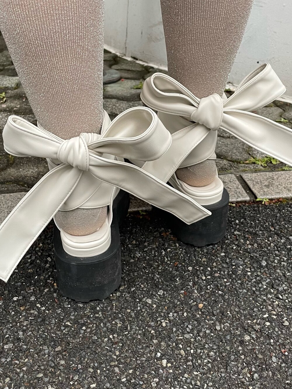 ブルー系のワンピース、ホワイト系のパンプスを着用したレディースの冬コーディネートの6枚目の写真