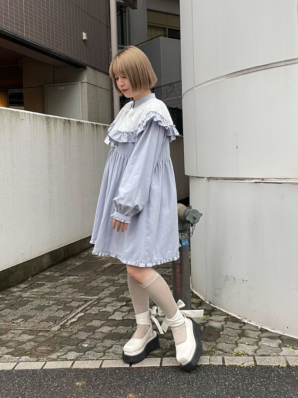 ブルー系のワンピース、ホワイト系のパンプスを着用したレディースの冬コーディネートの3枚目の写真