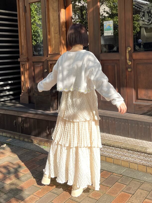 グレー系のカーディガン/ボレロ、ホワイト系のスカート、ホワイト系のローファーを着用したレディースの夏コーディネートの4枚目の写真