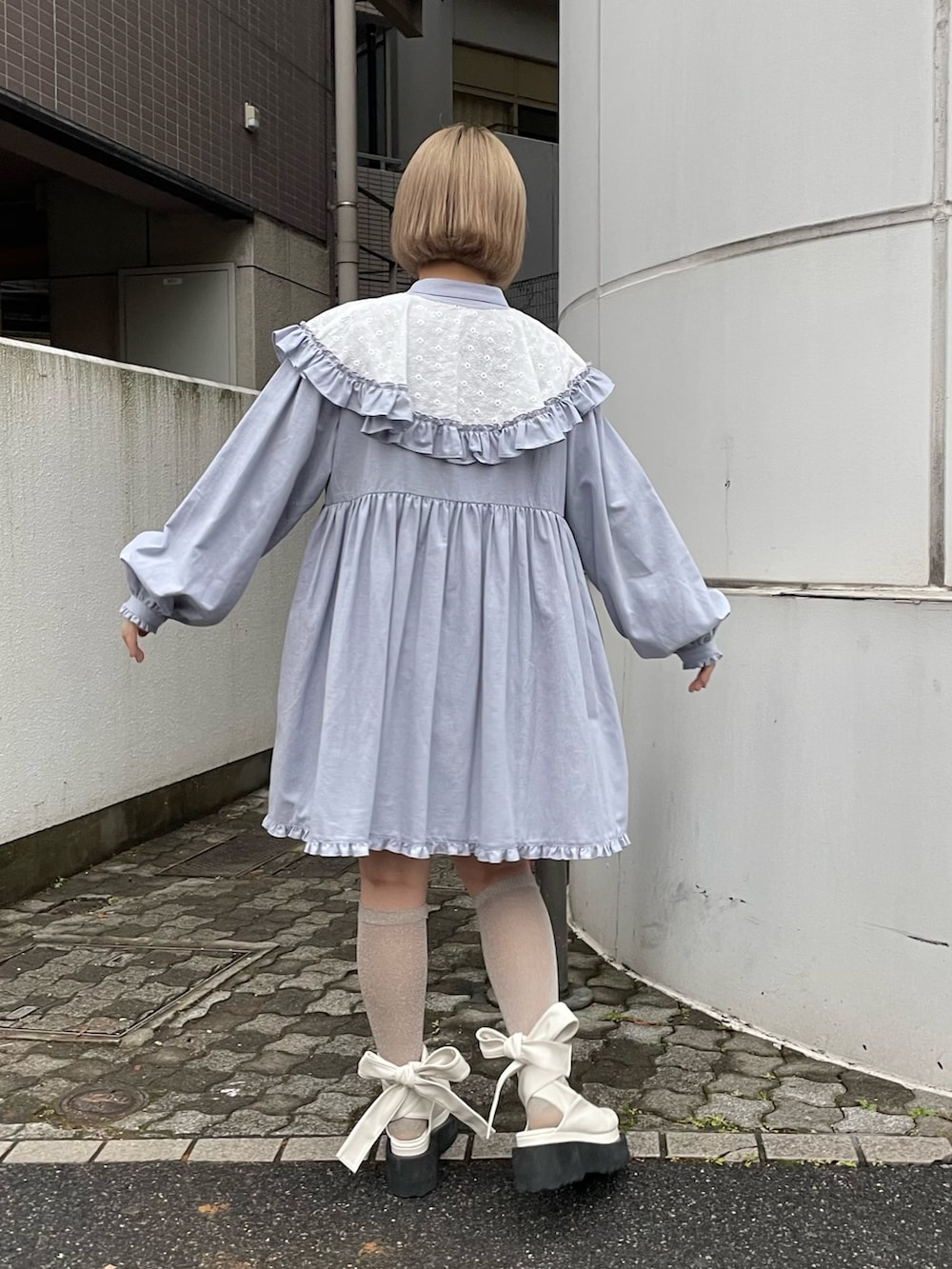 ブルー系のワンピース、ホワイト系のパンプスを着用したレディースの冬コーディネートの2枚目の写真