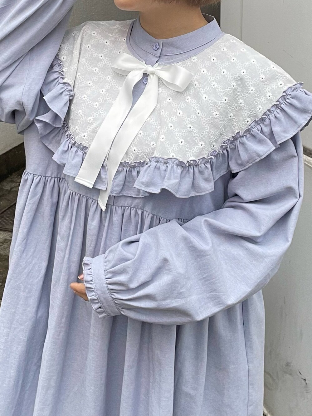 ブルー系のワンピース、ホワイト系のパンプスを着用したレディースの冬コーディネートの5枚目の写真