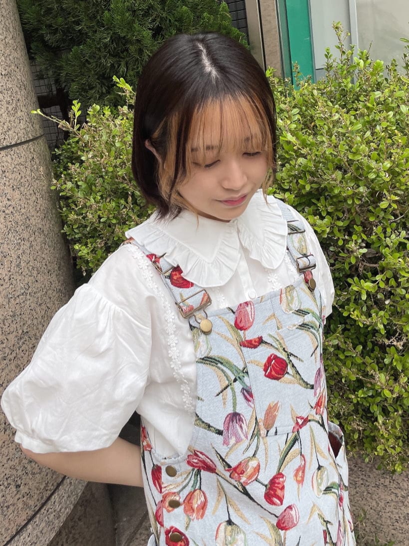 ブルー系のジャンパースカート、ホワイト系のサンダル、ホワイト系のハンドバッグを着用したレディースの春コーディネートの2枚目の写真