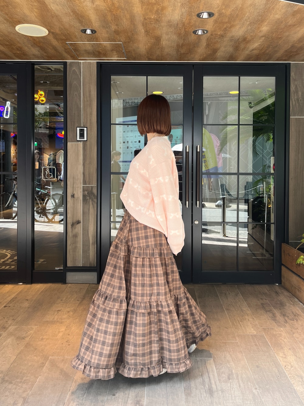 ピンク系のカーディガン/ボレロ、ブラウン系のスカート、ホワイト系のTシャツ/カットソーを着用したレディースの秋コーディネートの2枚目の写真