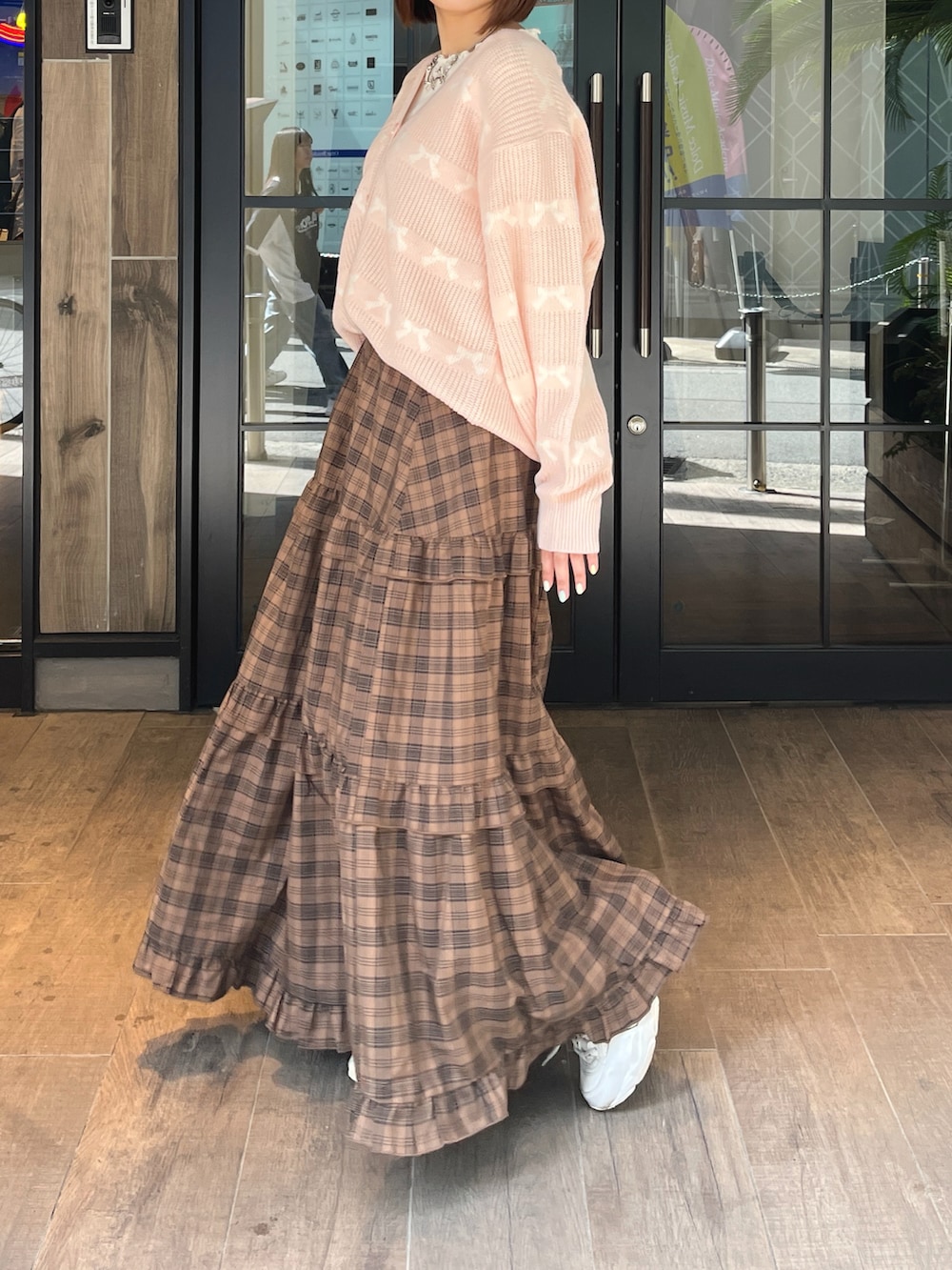 ピンク系のカーディガン/ボレロ、ブラウン系のスカート、ホワイト系のTシャツ/カットソーを着用したレディースの秋コーディネートの3枚目の写真