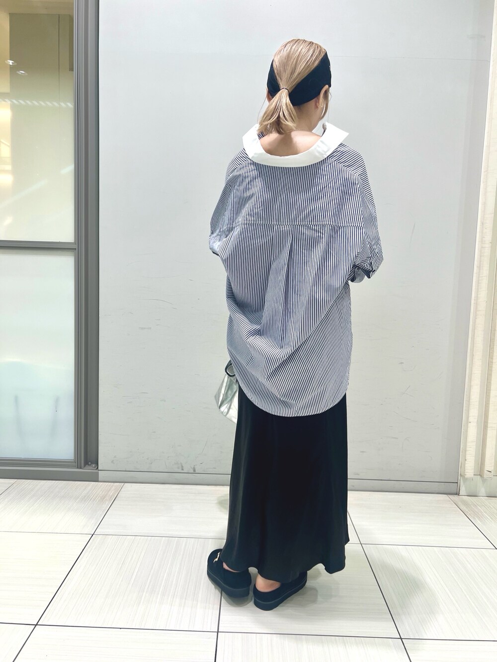 ブルー系のシャツ/ブラウス、ブラック系のスカート、ブラック系のトートバッグを着用したレディースの夏コーディネートの4枚目の写真