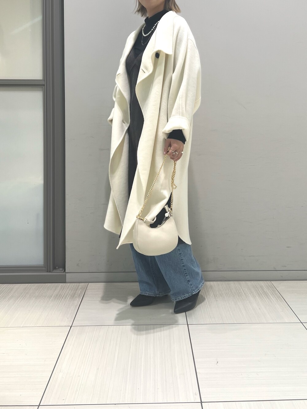 ホワイト系のその他アウター、ブラウン系のワンピース、ホワイト系のショルダーバッグを着用したレディースの冬コーディネートの6枚目の写真