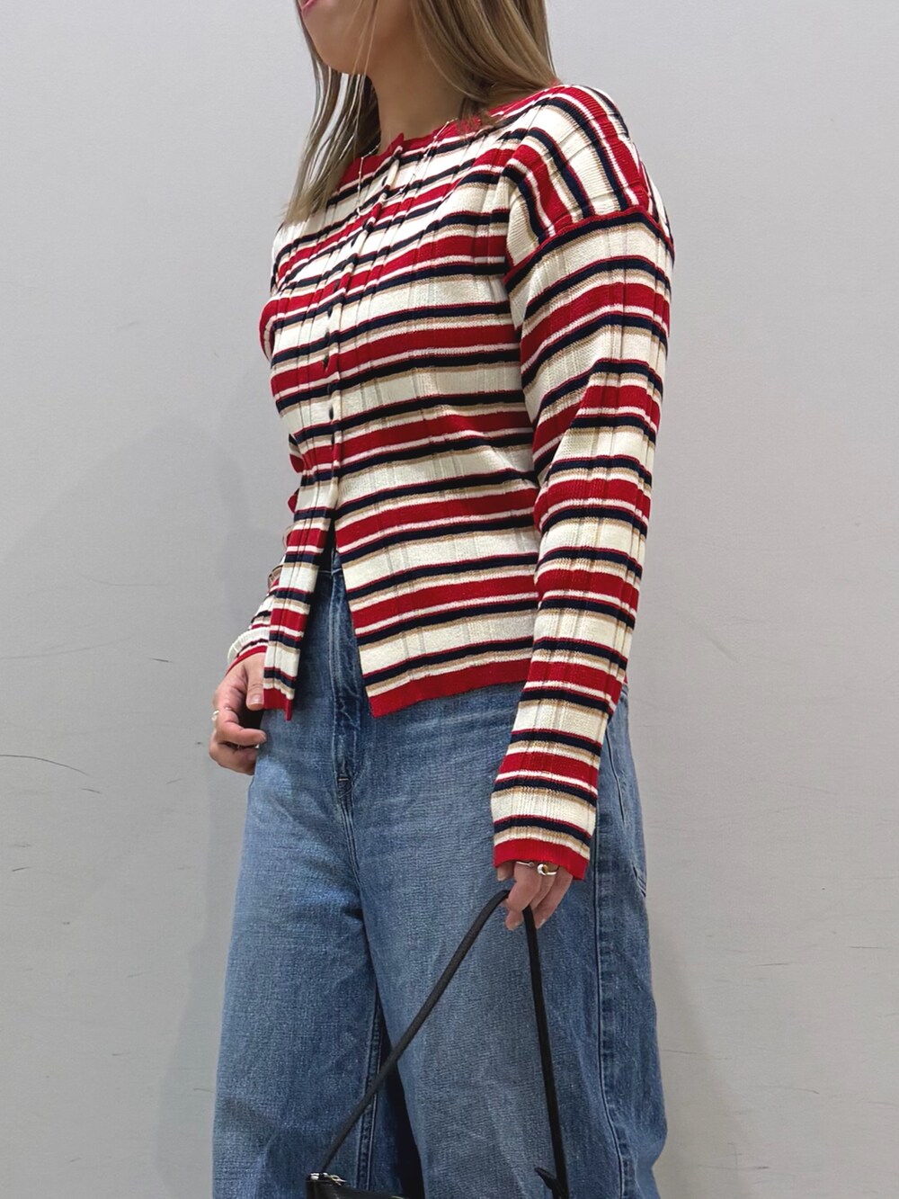 その他のニット/セーター、ブルー系のデニムパンツ、ブラック系のショルダーバッグを着用したレディースの冬コーディネートの7枚目の写真