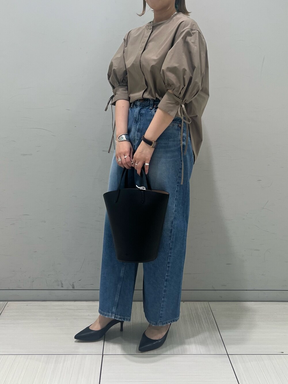 ブラウン系のシャツ/ブラウス、ブルー系のデニムパンツ、ブラック系のハンドバッグを着用したレディースの春コーディネートの4枚目の写真